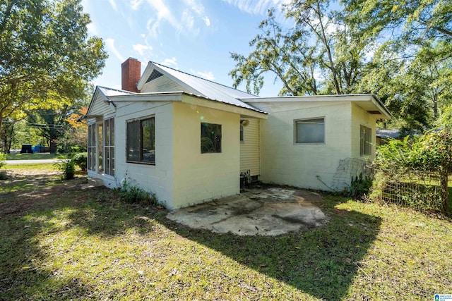 rear view of property with a lawn