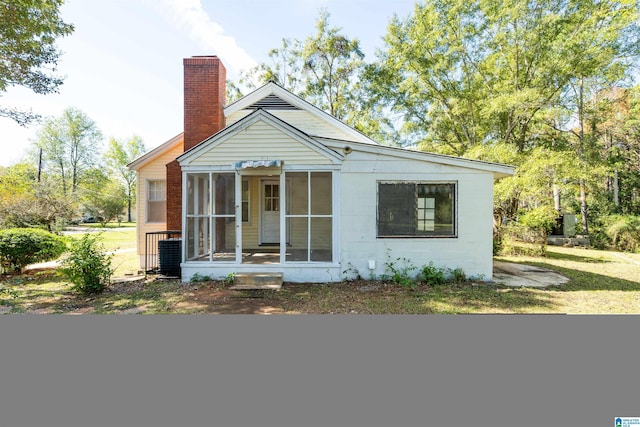 bungalow-style home with a sunroom and a front lawn