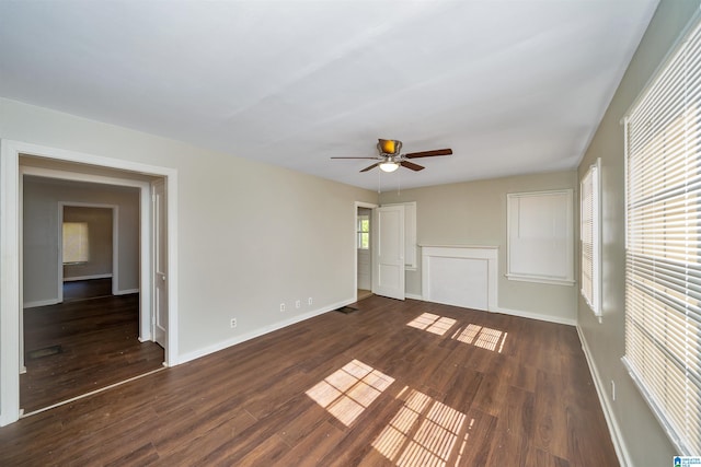 unfurnished living room with dark wood-type flooring and ceiling fan