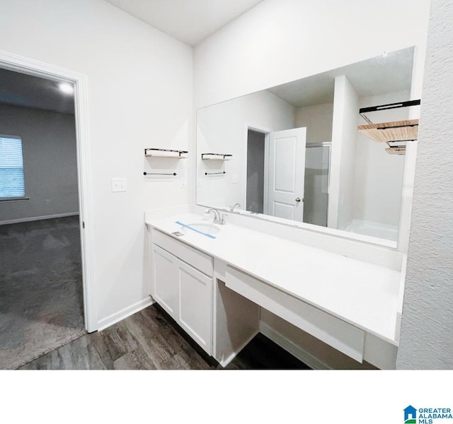 bathroom with hardwood / wood-style floors, vanity, and walk in shower