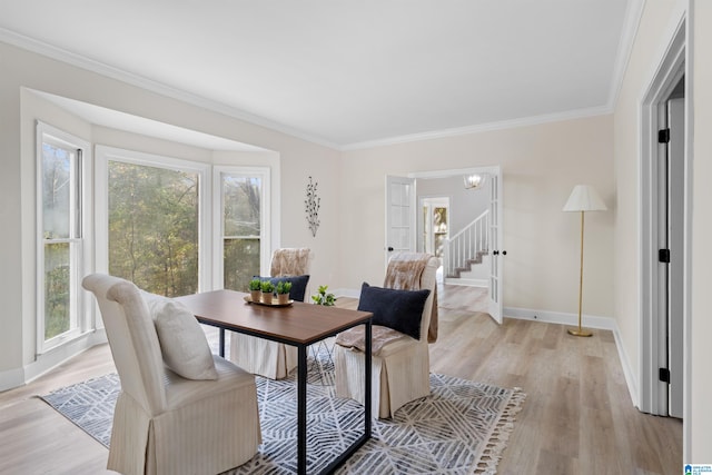 dining room featuring light wood-type flooring, crown molding, and plenty of natural light