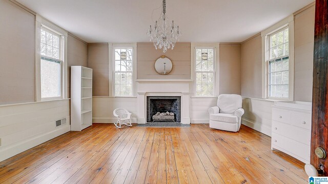 unfurnished room with light wood-type flooring and a notable chandelier