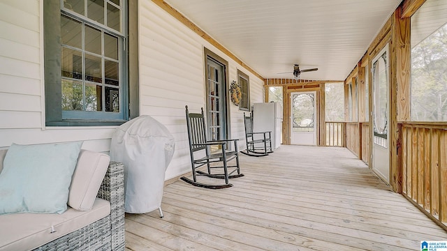 wooden deck featuring covered porch and ceiling fan