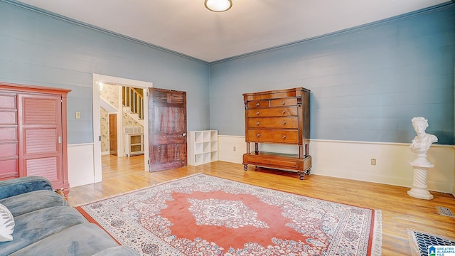 living area with hardwood / wood-style floors and crown molding