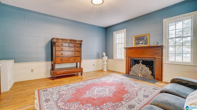 sitting room with hardwood / wood-style flooring, ornamental molding, and plenty of natural light