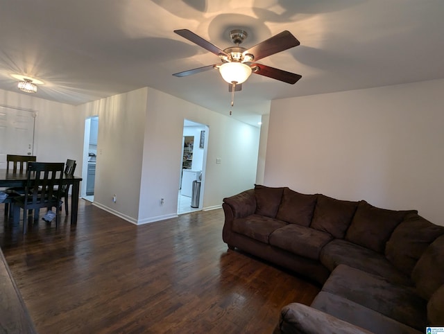 living room featuring ceiling fan and dark hardwood / wood-style flooring