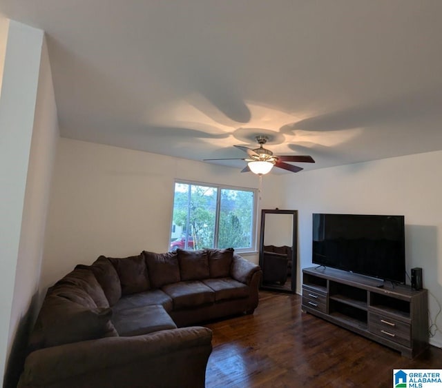 living room featuring dark wood-type flooring and ceiling fan