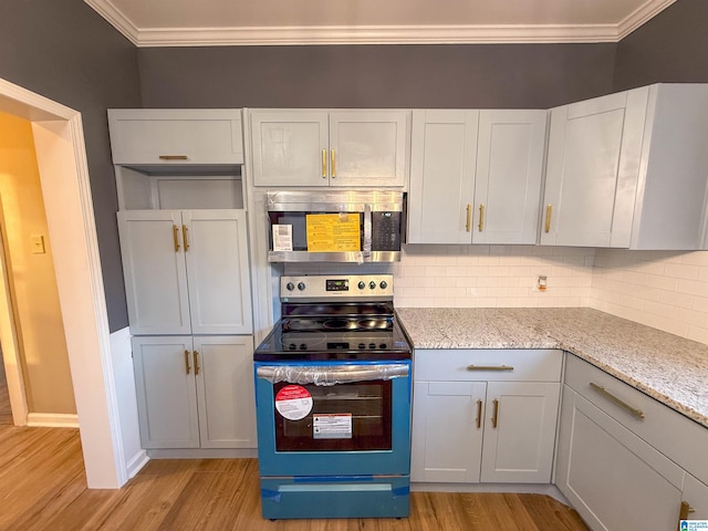 kitchen with light stone countertops, white cabinetry, light wood-type flooring, and black / electric stove