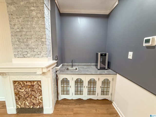 washroom with crown molding, sink, and light hardwood / wood-style flooring