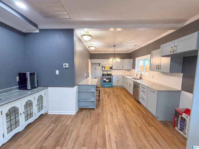 kitchen with light stone countertops, stainless steel appliances, sink, light hardwood / wood-style floors, and hanging light fixtures