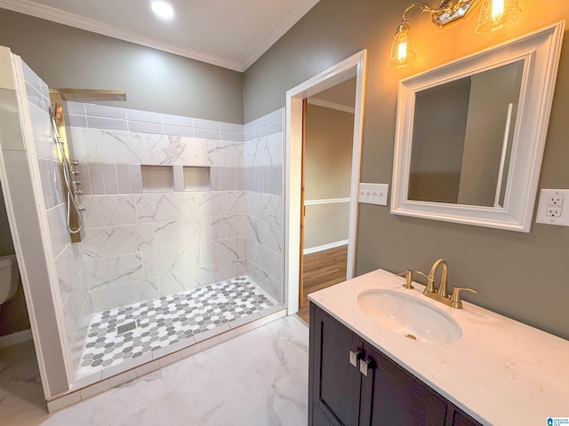 bathroom with a tile shower, vanity, and crown molding