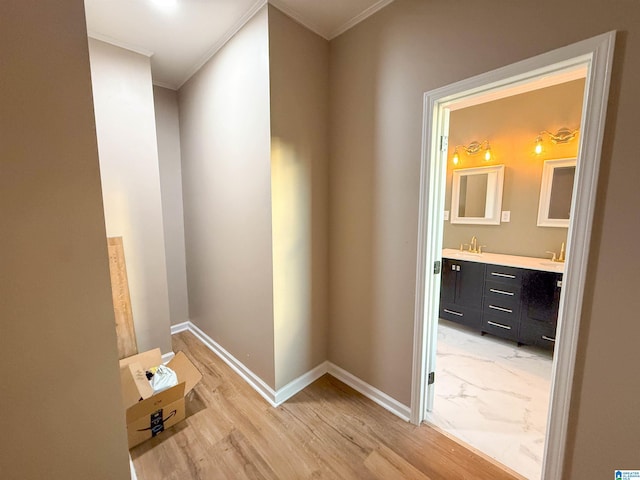 corridor with hardwood / wood-style floors, ornamental molding, and sink