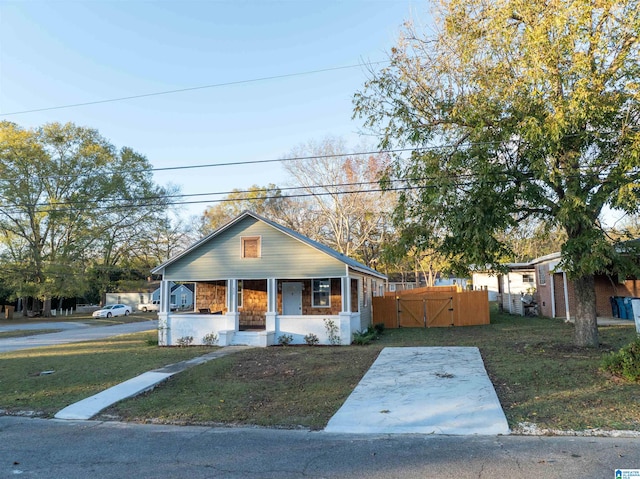 bungalow-style house with a front lawn and covered porch