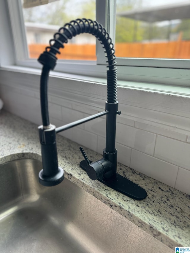 interior details featuring light stone counters and sink