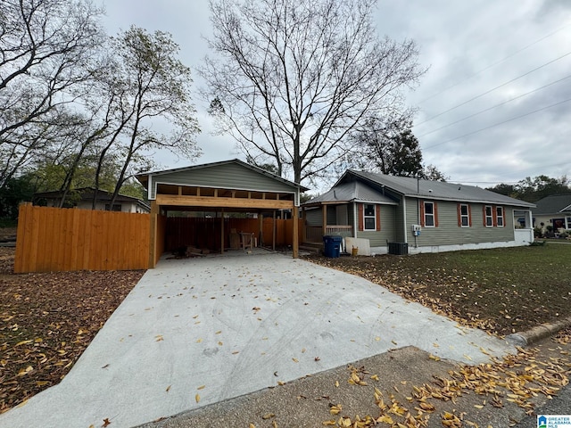 view of property exterior with a carport, cooling unit, and a lawn