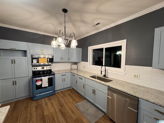 kitchen with gray cabinetry, backsplash, sink, appliances with stainless steel finishes, and decorative light fixtures