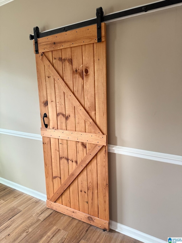 interior details featuring a barn door and wood-type flooring