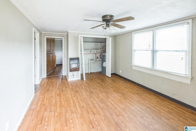 unfurnished bedroom with light hardwood / wood-style floors, ceiling fan, heating unit, a textured ceiling, and crown molding