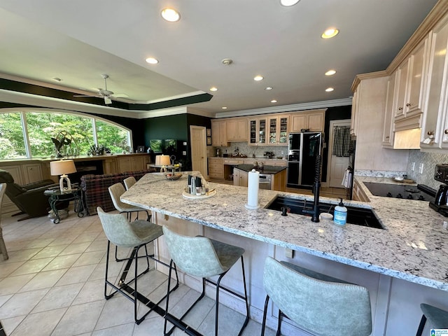 kitchen with kitchen peninsula, crown molding, and light stone countertops