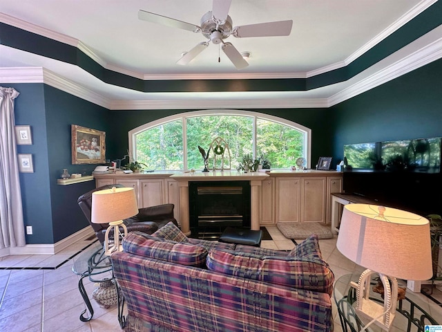 tiled cinema featuring ceiling fan, a raised ceiling, and crown molding