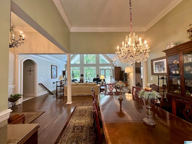 dining space with dark hardwood / wood-style flooring, crown molding, and decorative columns