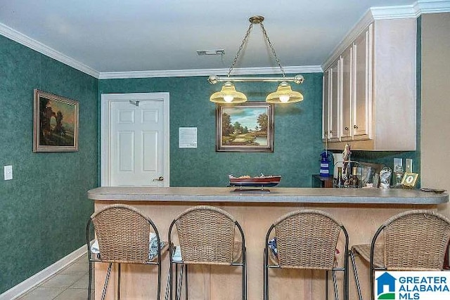 kitchen featuring ornamental molding, hanging light fixtures, light tile patterned floors, and a breakfast bar