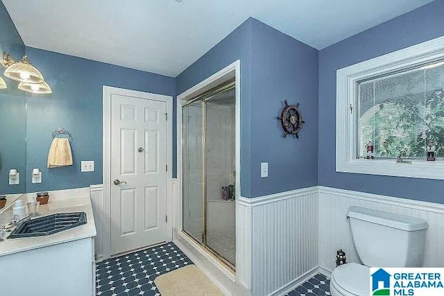 bathroom featuring toilet, an enclosed shower, and sink