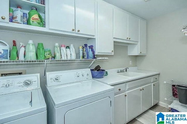 laundry area with washing machine and dryer, cabinets, and sink