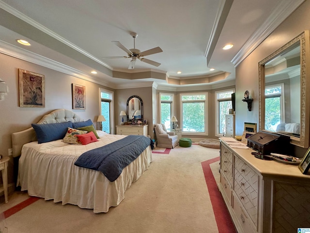 carpeted bedroom featuring ceiling fan, a tray ceiling, and ornamental molding