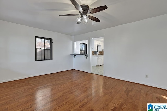 unfurnished living room with ceiling fan and light hardwood / wood-style flooring