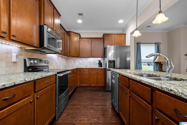 kitchen with light stone counters, stainless steel appliances, dark wood-type flooring, sink, and decorative light fixtures