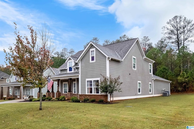 view of front of home featuring a front yard, covered porch, and central air condition unit