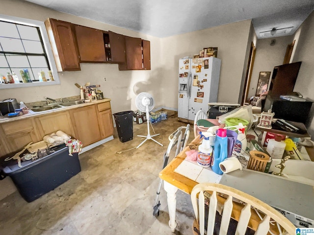 kitchen featuring white refrigerator with ice dispenser and sink