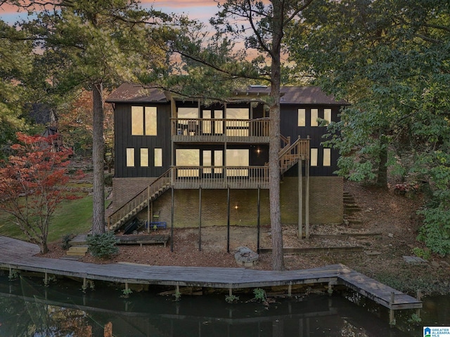 back house at dusk featuring a deck