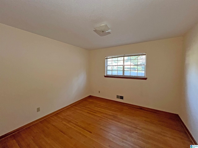 spare room with wood-type flooring and a textured ceiling