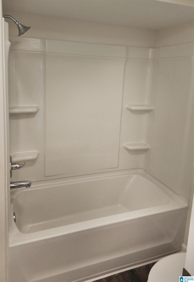 bathroom featuring hardwood / wood-style flooring, toilet, and shower / bathing tub combination