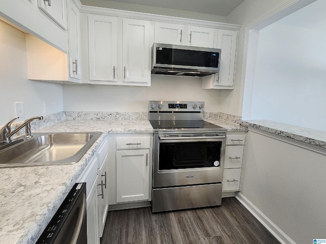 kitchen with dark hardwood / wood-style flooring, white cabinets, sink, light stone countertops, and appliances with stainless steel finishes