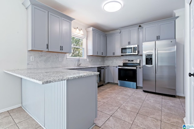 kitchen with light tile patterned flooring, decorative backsplash, and appliances with stainless steel finishes