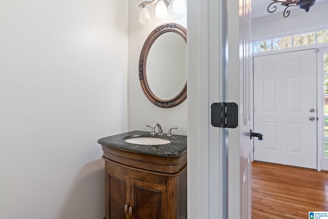 bathroom featuring vanity, hardwood / wood-style floors, and crown molding