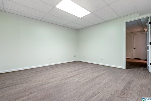 unfurnished room with a drop ceiling and light hardwood / wood-style floors