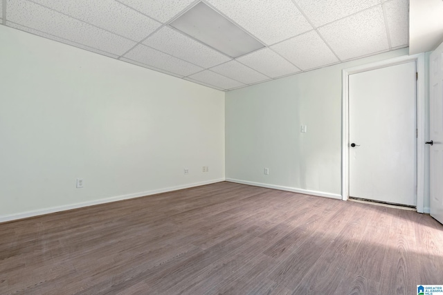 unfurnished room with a paneled ceiling and wood-type flooring