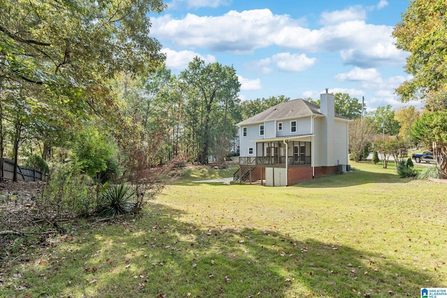 view of yard featuring central AC unit, a sunroom, and a deck