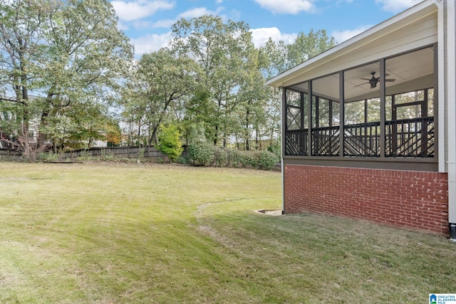 view of yard with ceiling fan and a sunroom