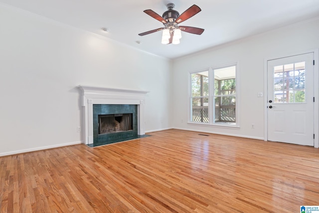 unfurnished living room featuring a fireplace, light hardwood / wood-style flooring, ceiling fan, and crown molding