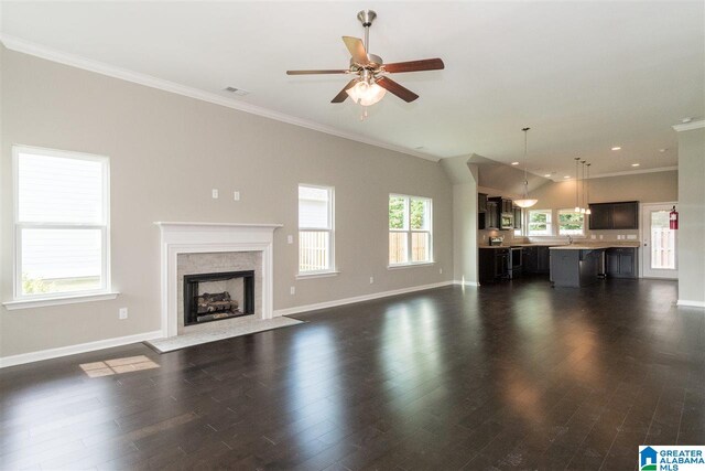 unfurnished living room with dark wood-type flooring, ceiling fan, crown molding, and a high end fireplace