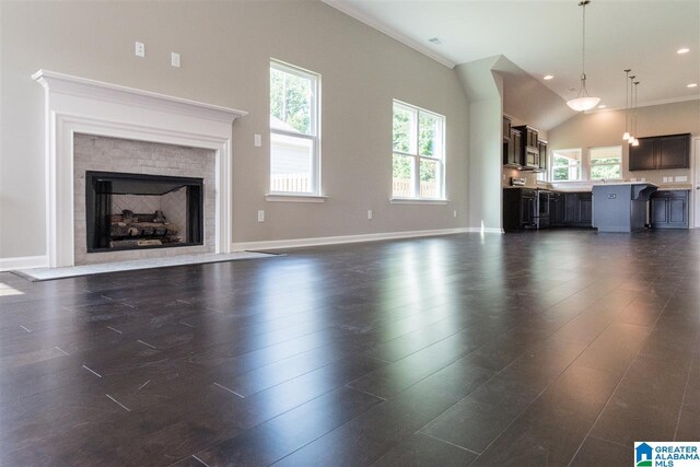 unfurnished living room with dark hardwood / wood-style flooring, lofted ceiling, and crown molding