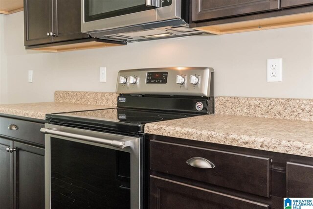 kitchen with dark brown cabinetry and appliances with stainless steel finishes