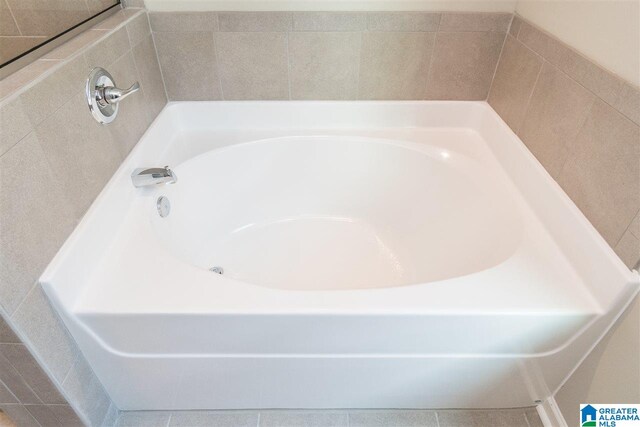 bathroom with a tub to relax in and tile patterned floors