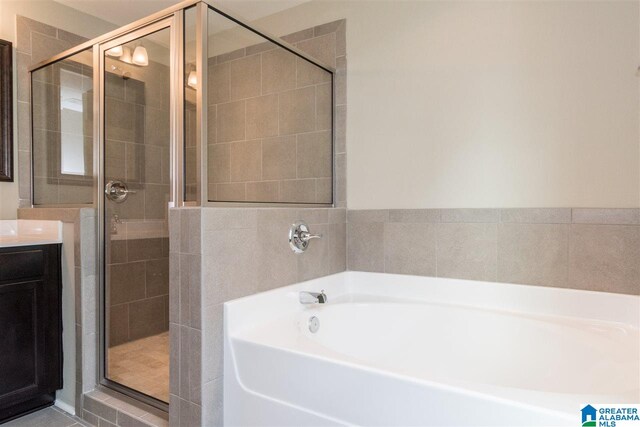 bathroom featuring vanity and independent shower and bath