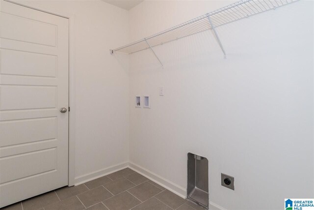 laundry room with hookup for an electric dryer, washer hookup, and dark tile patterned flooring